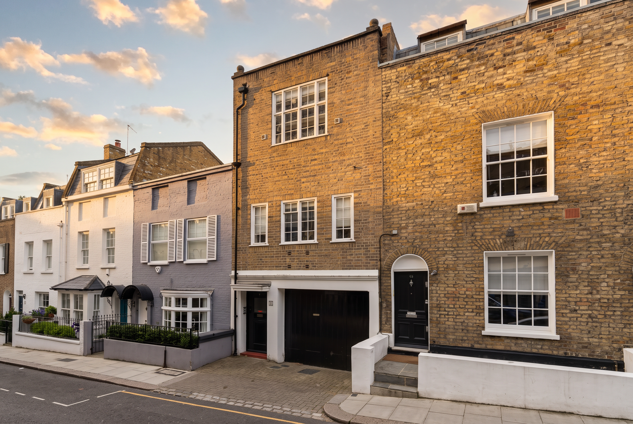 Colour photograph of 91A Peel Street at golden hour — brick terraced house with a black timber garage door and white-painted surround